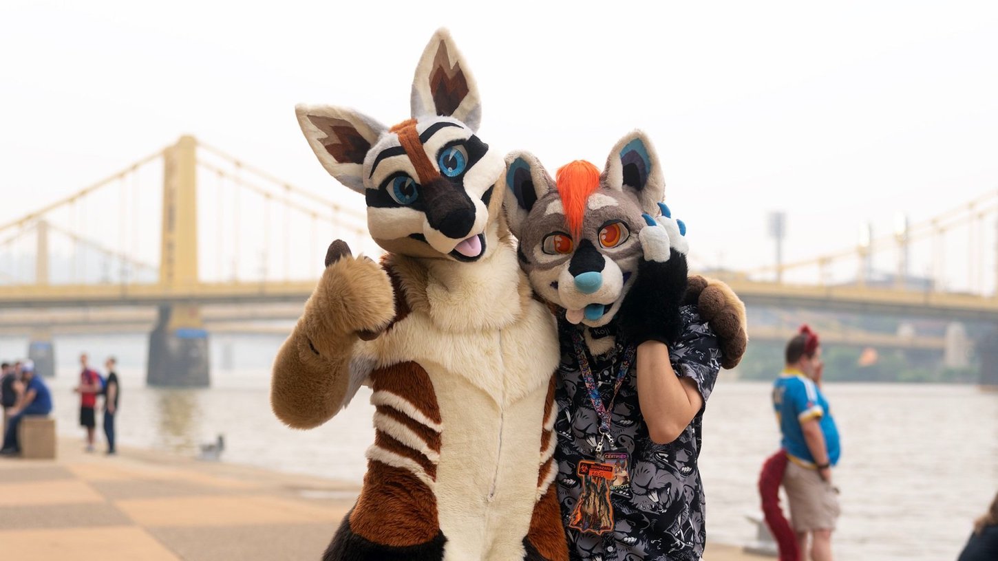 Two fursuiters at the Allegheny waterfront, giving a thumbs up to the camera.