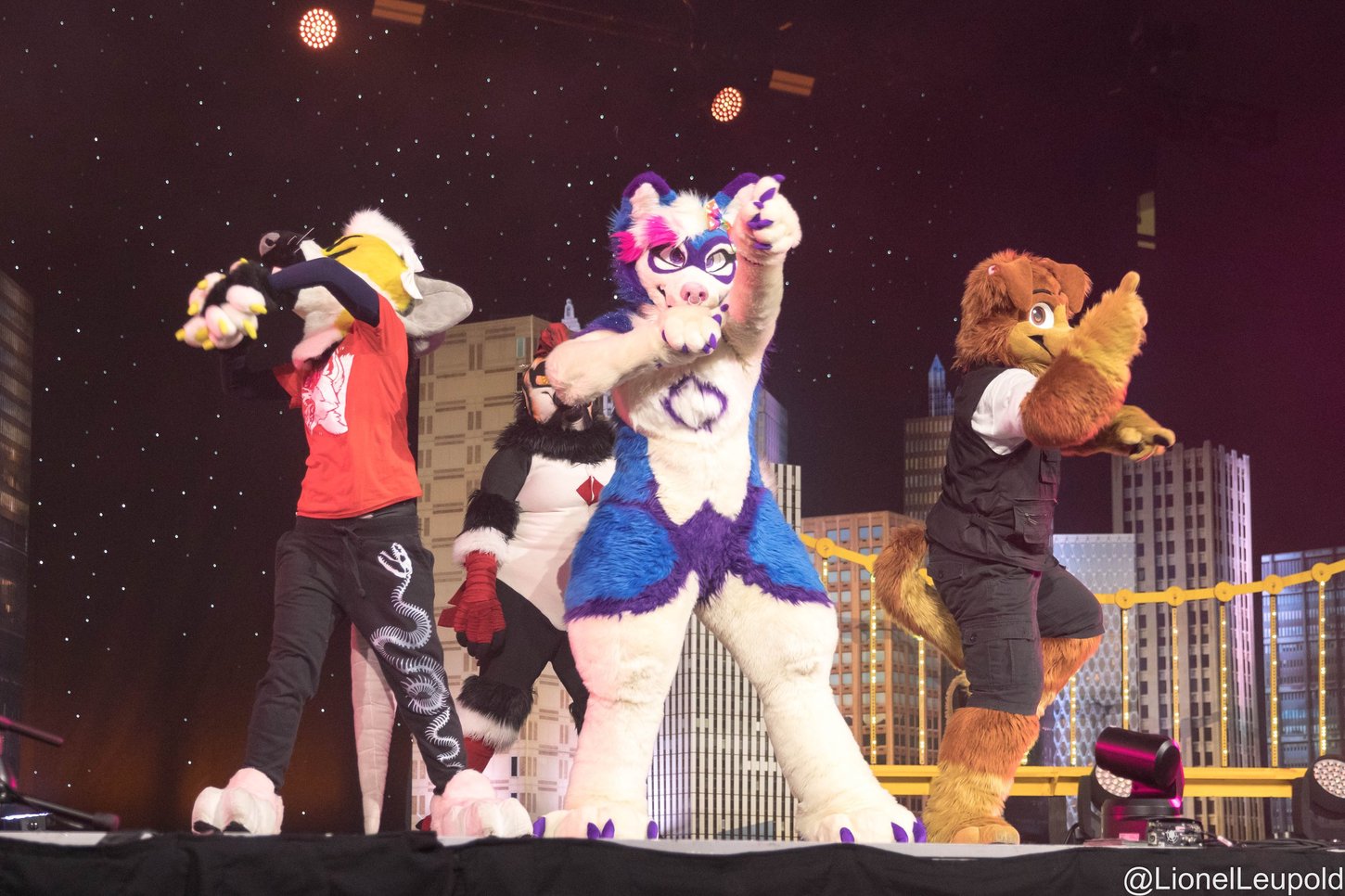 A group of four fursuit dancers perfoming at the Anthrocon 2023 Dance Competition.