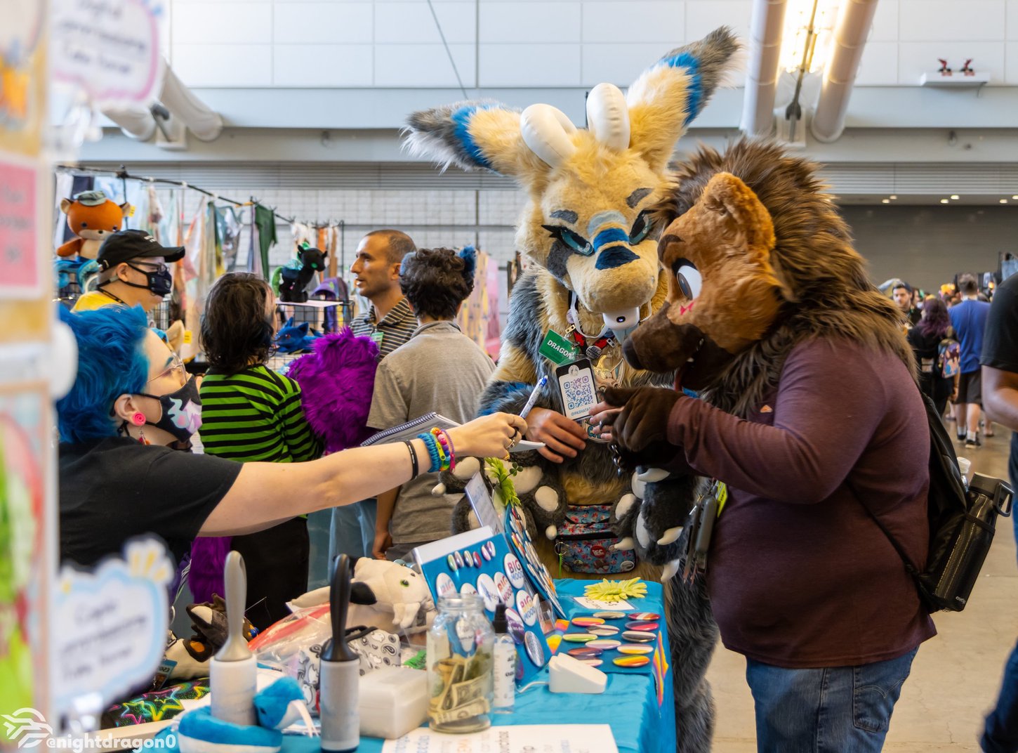 A vendor and a costumed customer performing a transaction in Anthrocon's Dealers Room.