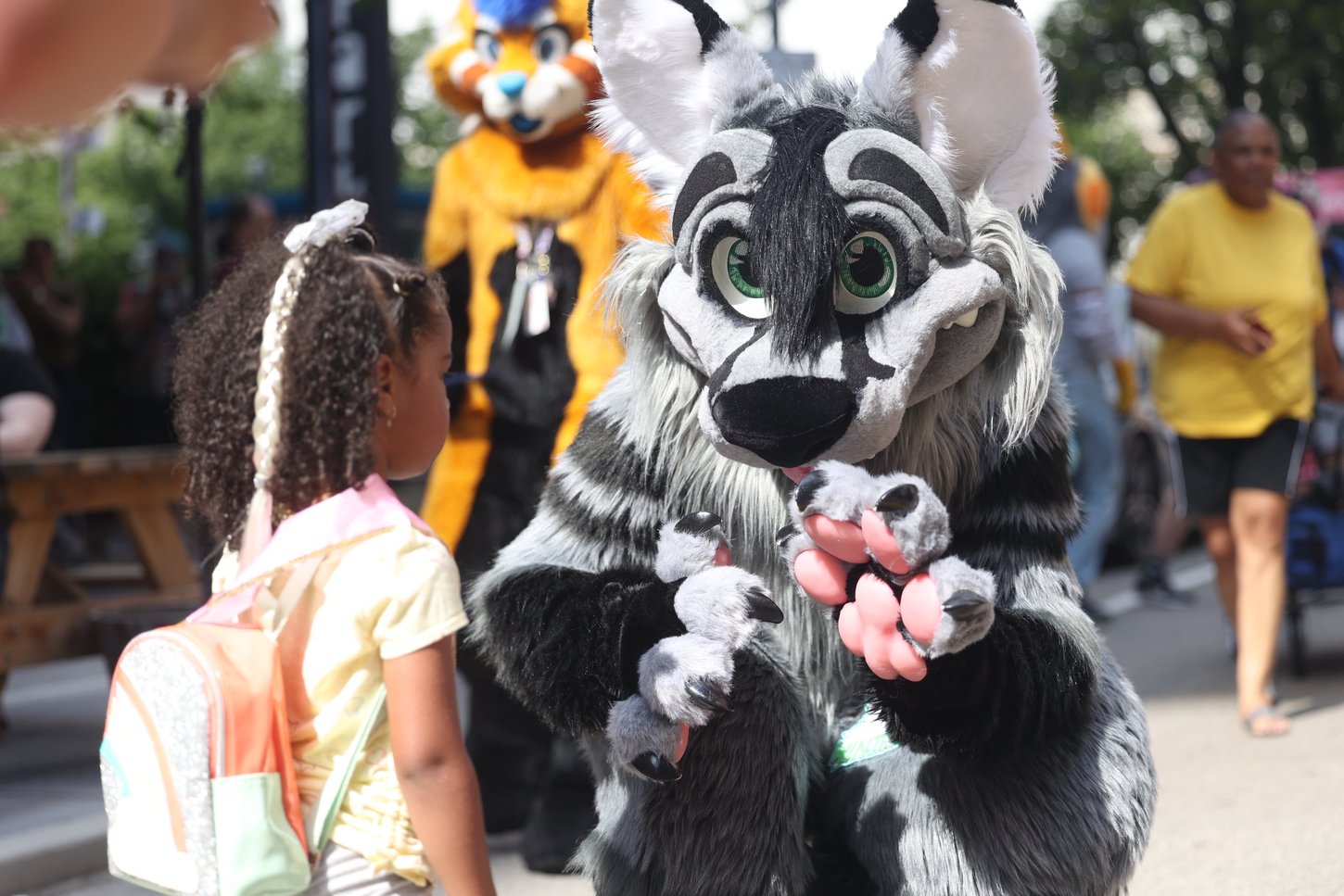 A fursuiter with a child at the Block Party.